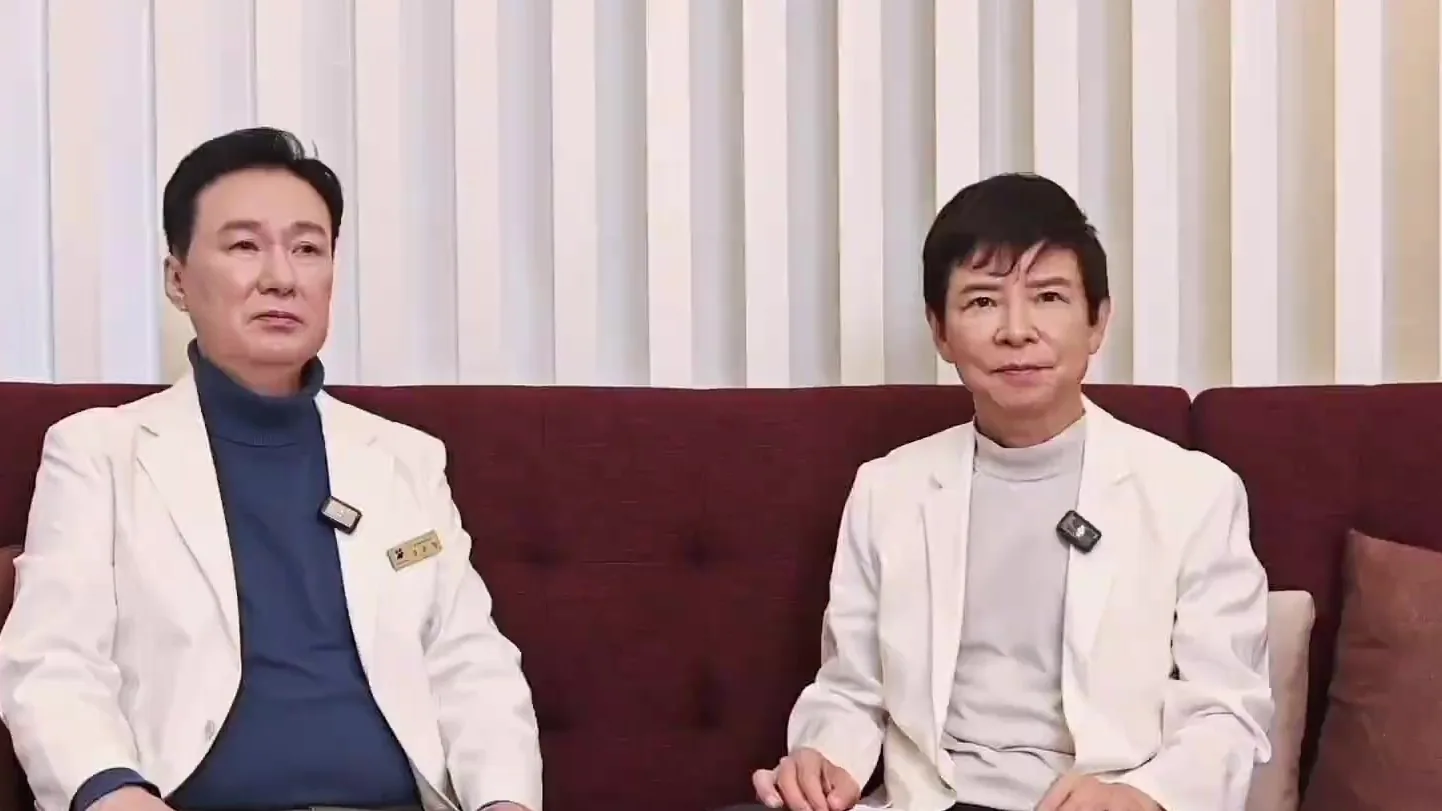 흰 가운을 입은 의사 두 명이 소파에 나란히 앉아 있는 모습